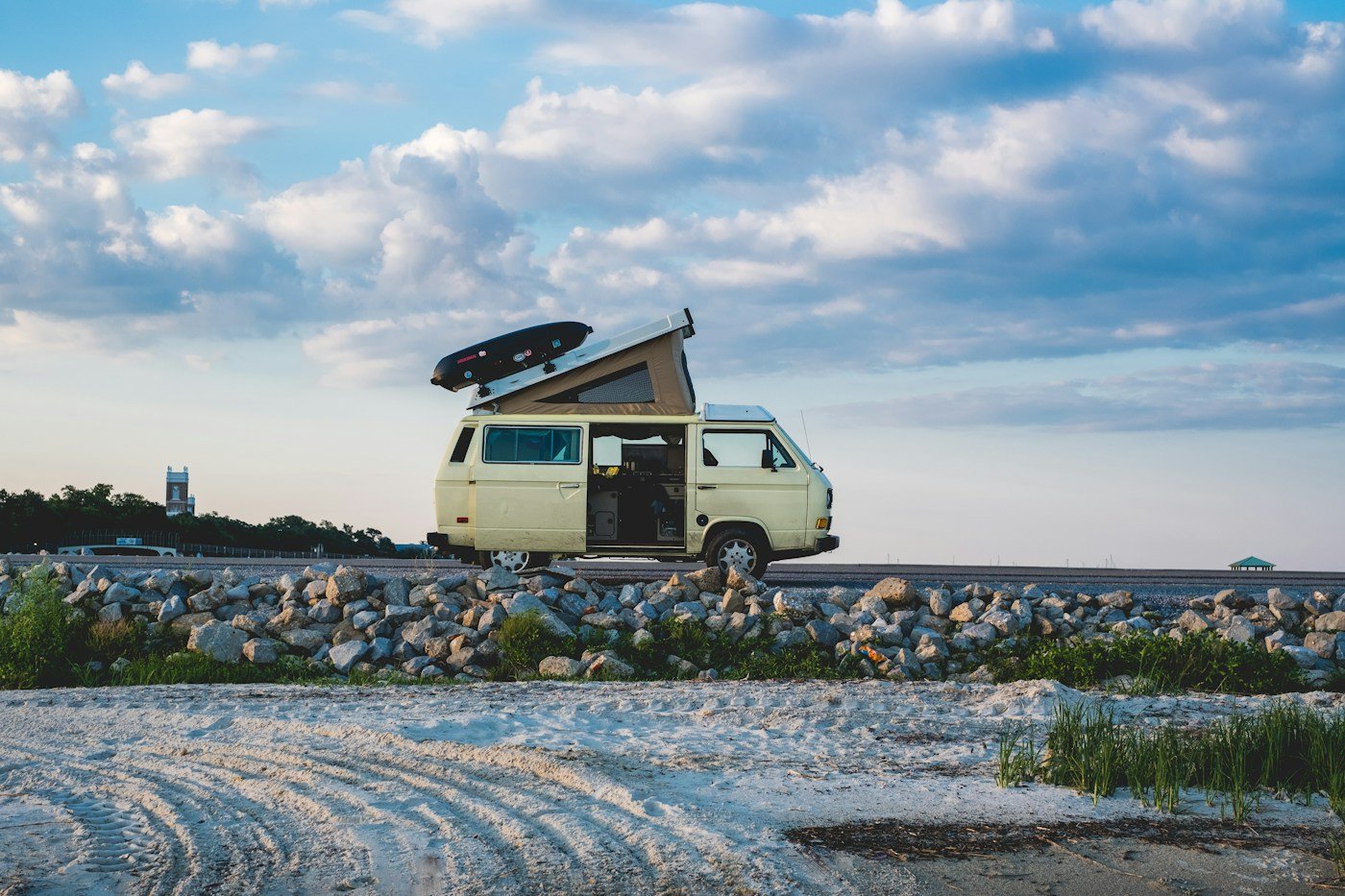 Furgoneta camper con techo elevable estacionada junto a la costa