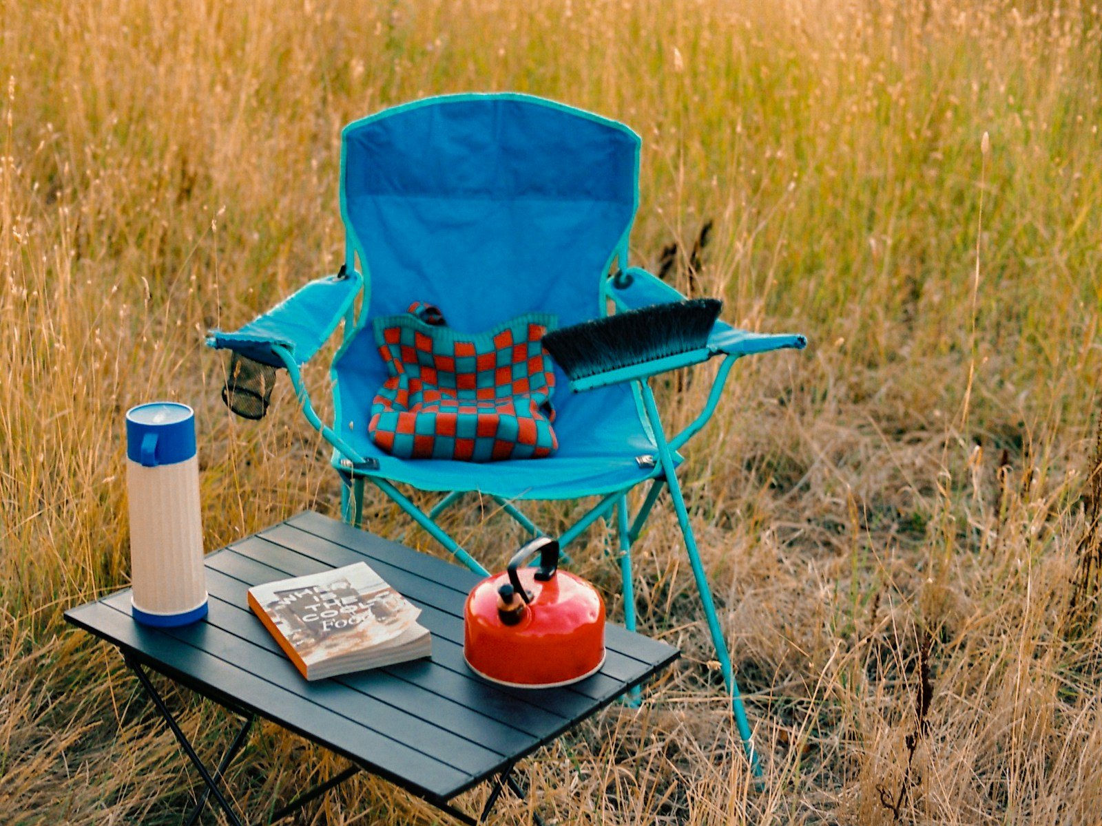 Silla plegable de camping junto a una mesa auxiliar