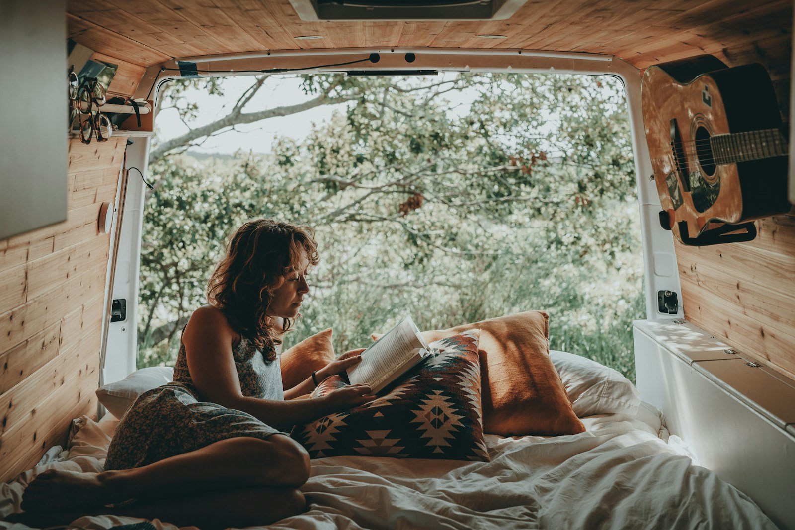 Cama en el interior de una camper con puertas traseras abiertas