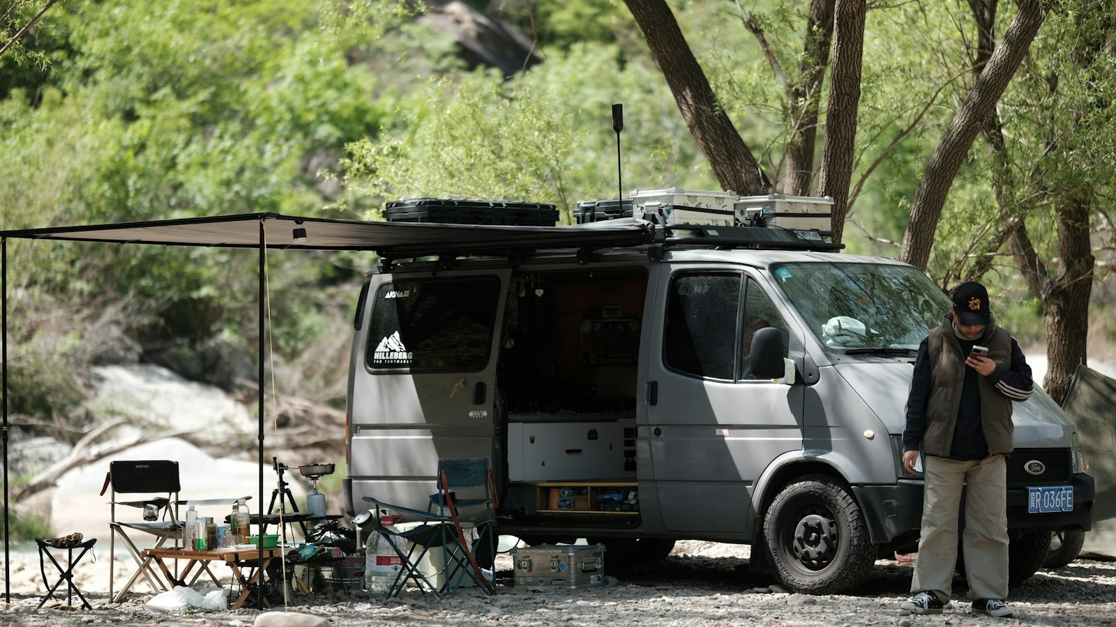 Furgoneta camper con toldo desplegado en una zona de acampada