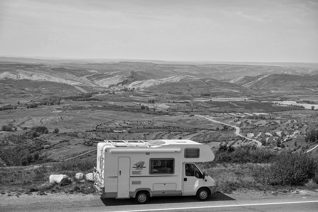 Autocaravana en una carretera rodeada de un paisaje abierto