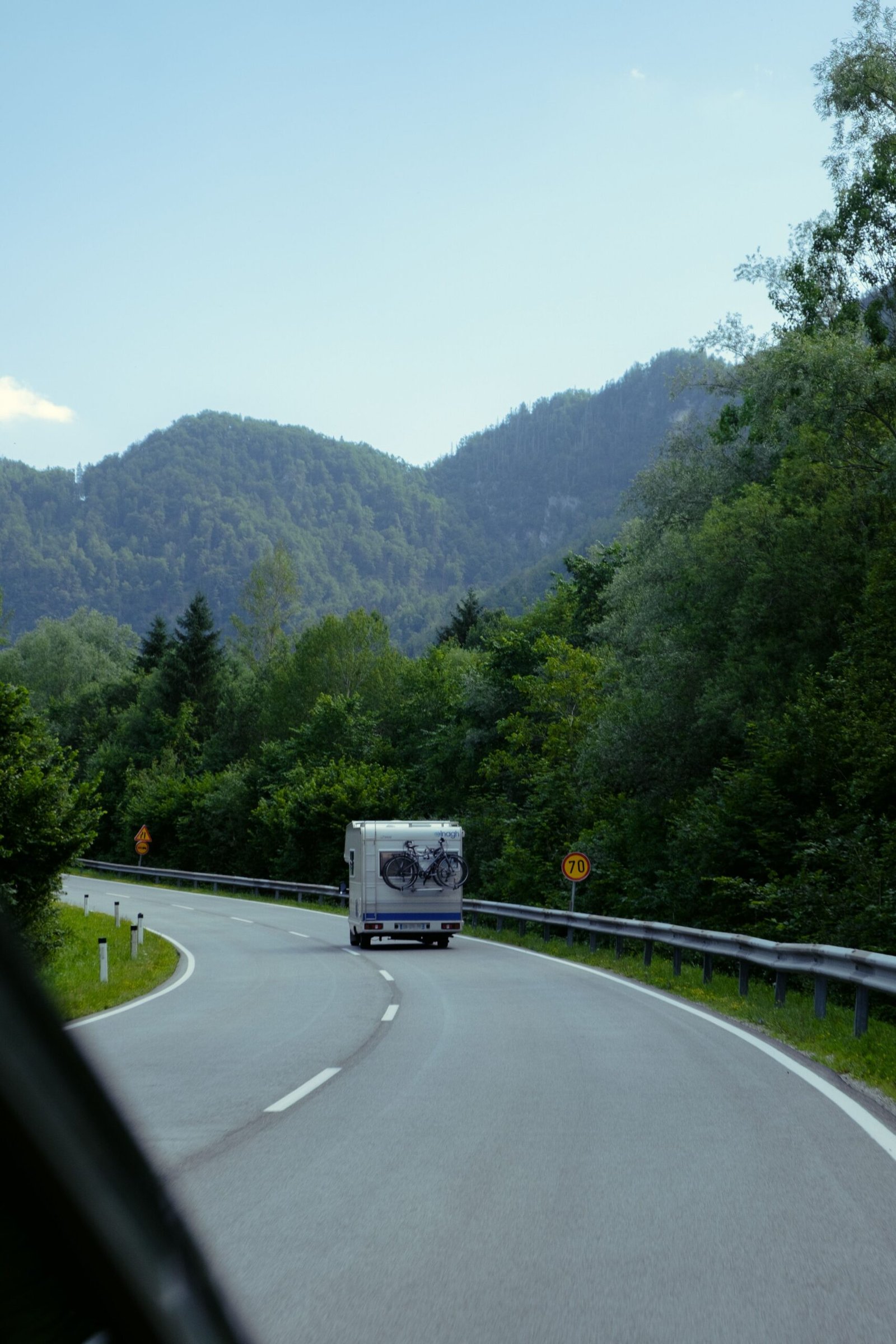Camper circulando entre bosque y montaña