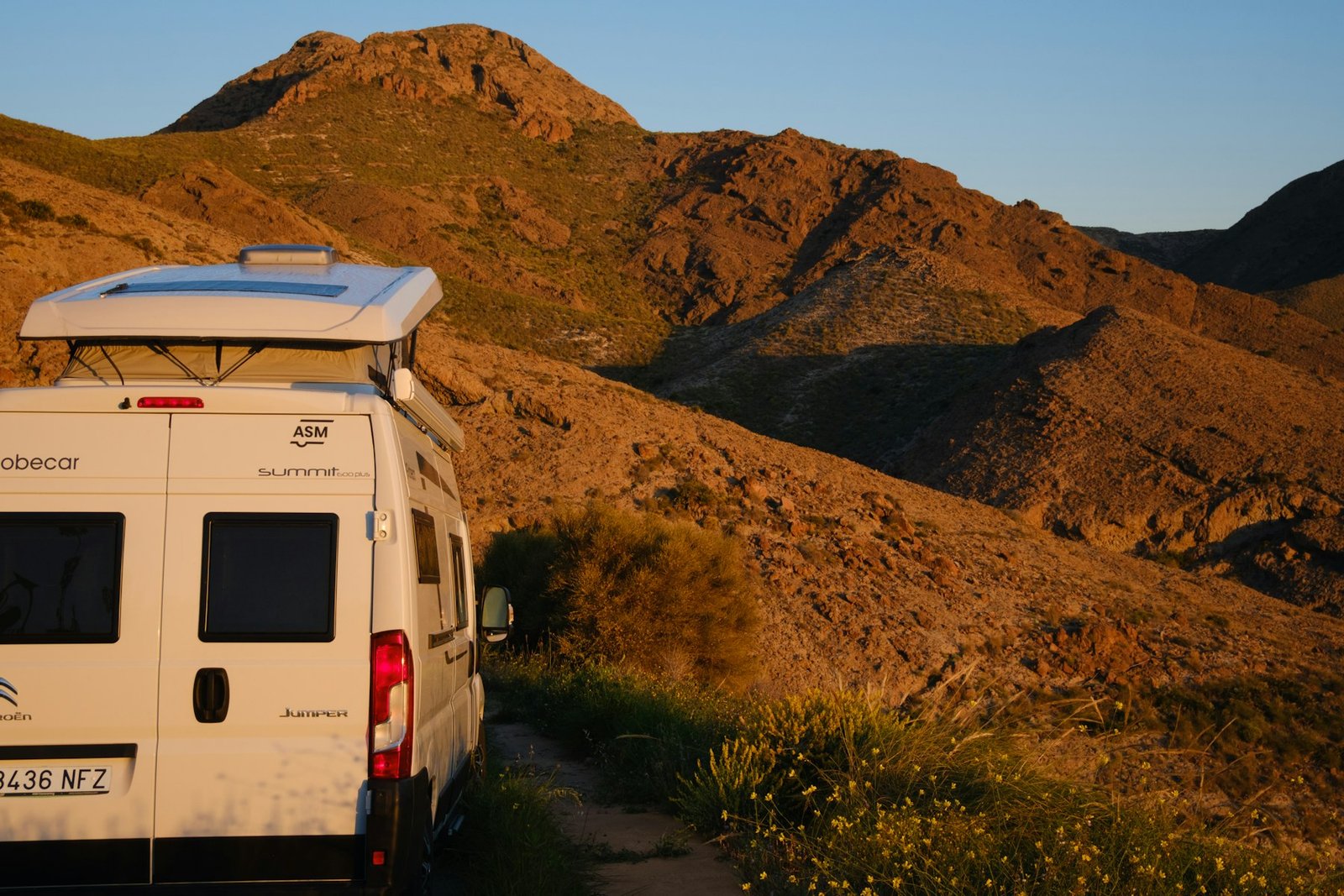 Furgoneta camper en carretera de montaña al atardecer