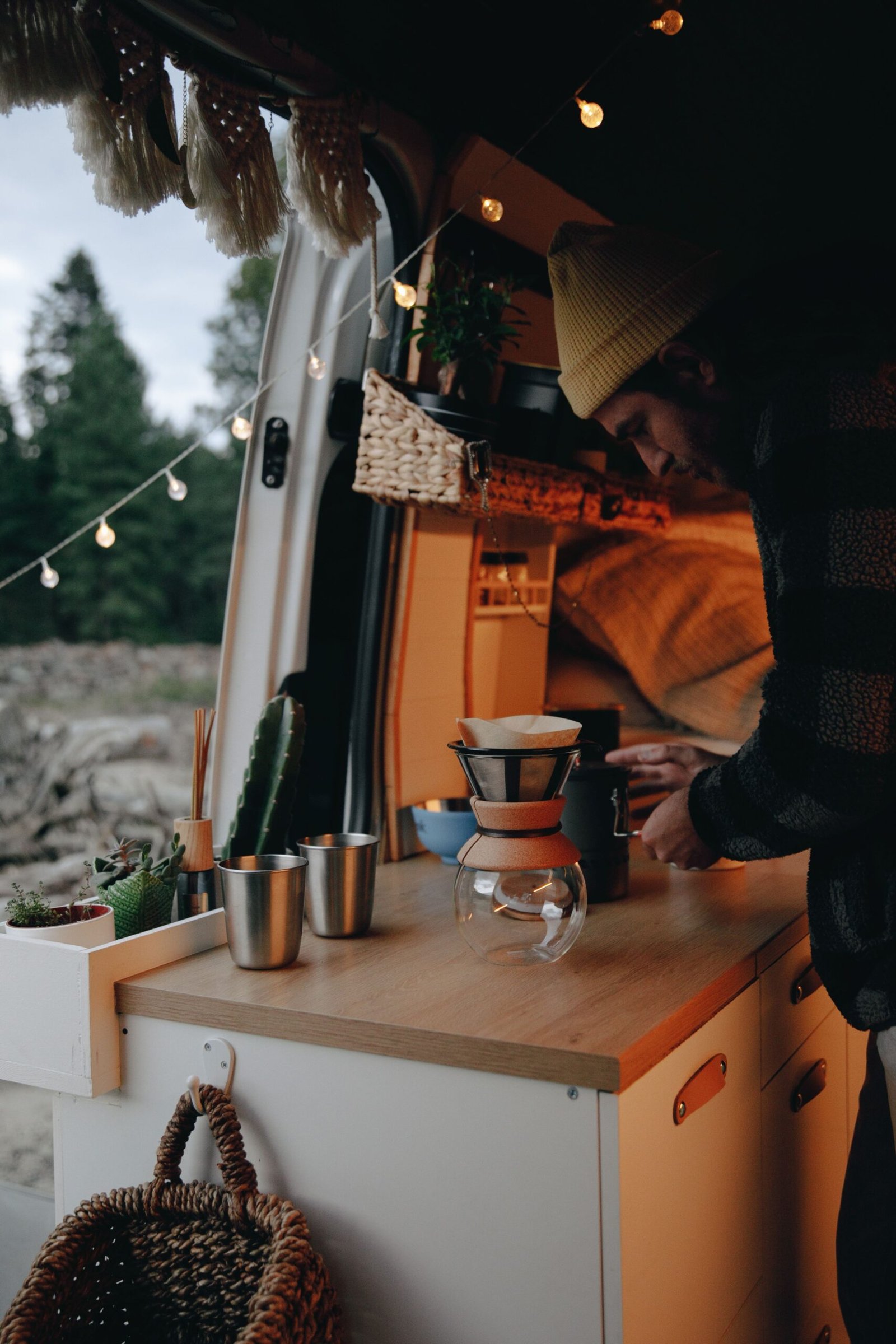 Interior de una camper con cocina de madera y café preparado durante una escapada