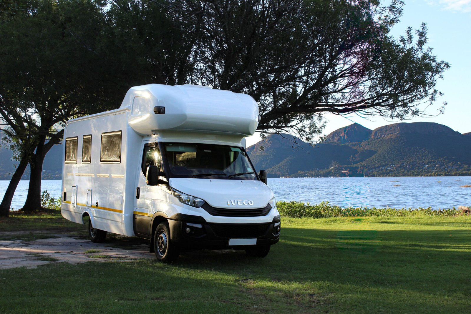 Camper junto a un lago y montañas durante un viaje