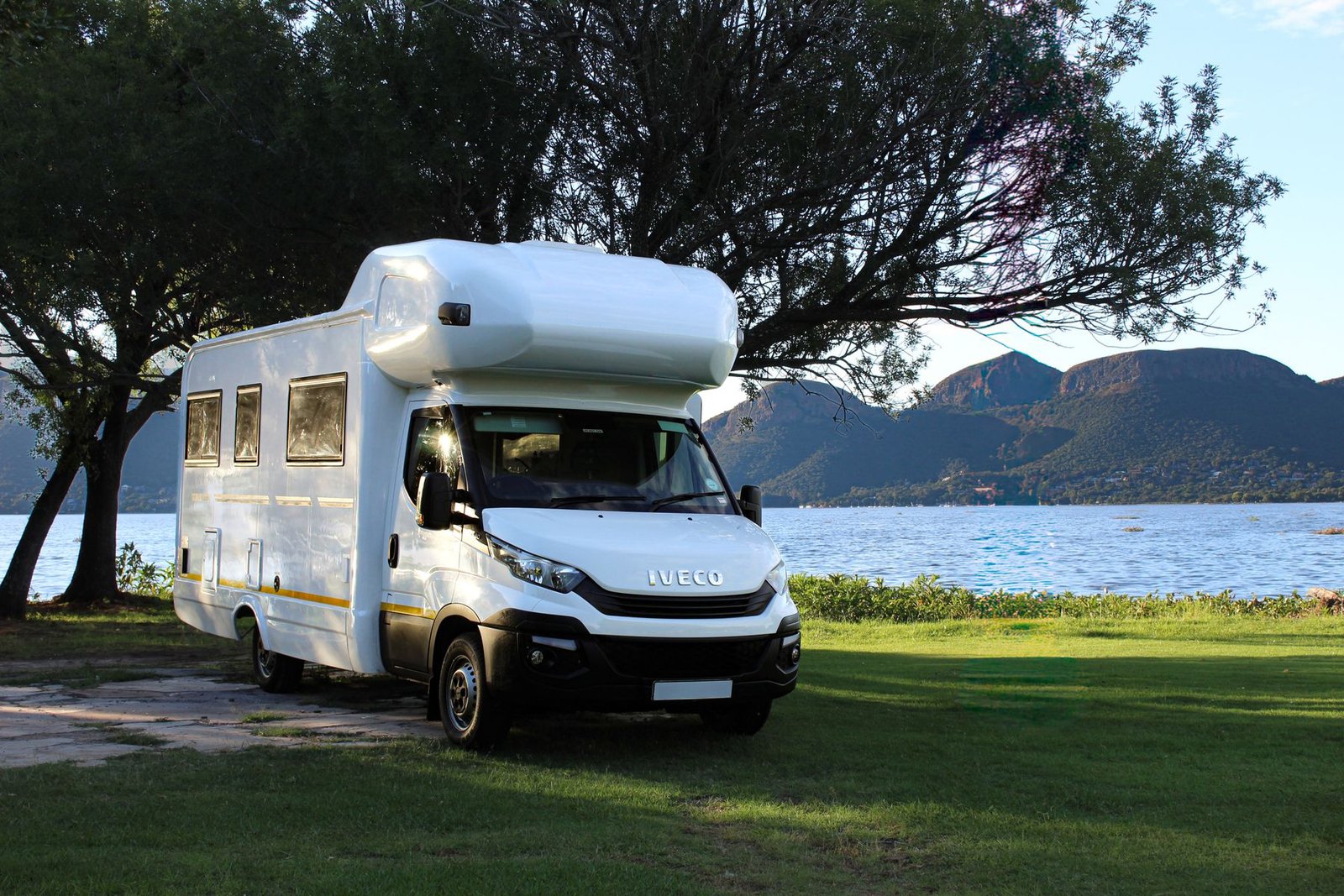 Camper junto a lago y montañas como ejemplo de proyecto por vehículo