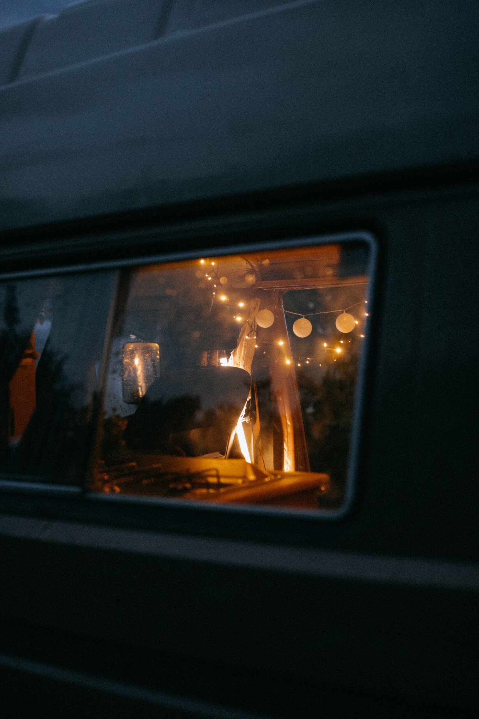 Interior de camper iluminado con guirnaldas de luz cálida durante la noche