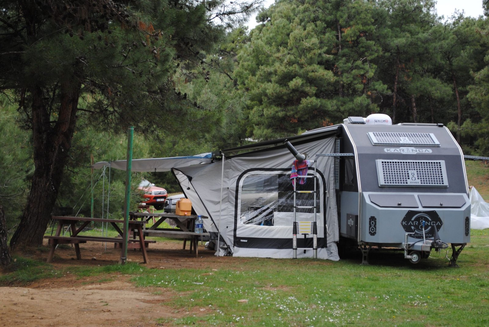 Caravana instalada en un camping rodeado de bosque