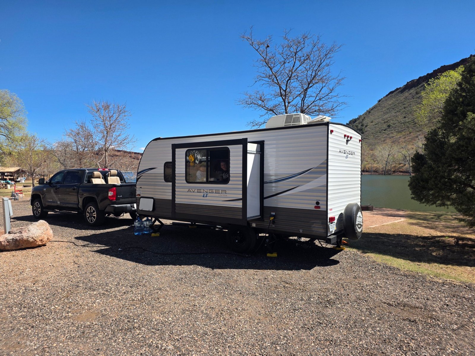 Caravana instalada junto a un lago con espacio para gestionar agua en la parcela