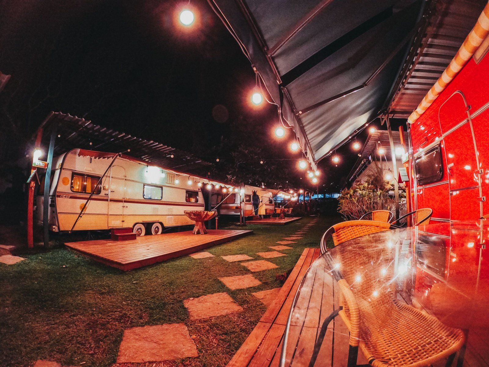 Caravanas iluminadas con guirnaldas en un camping de noche