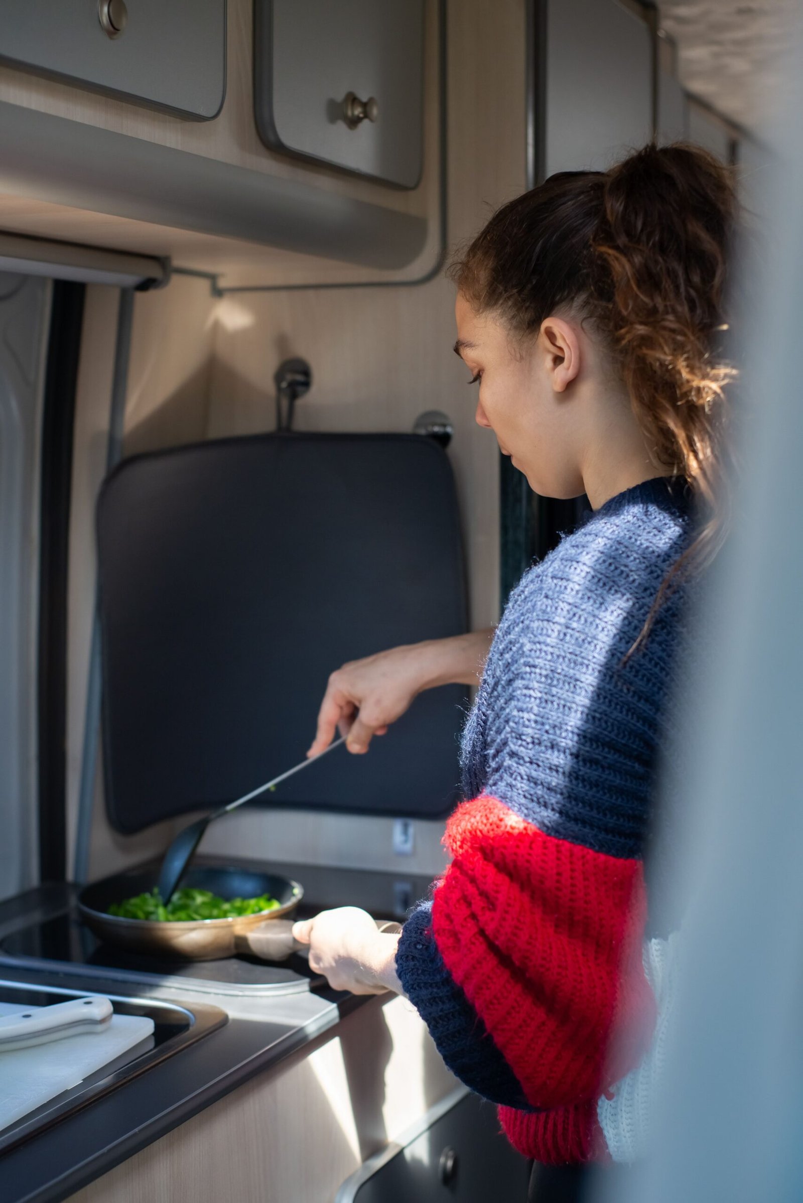 Persona cocinando dentro de una camper
