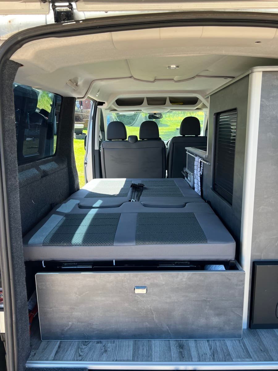 Interior de Peugeot Expert camper con cama trasera desplegada