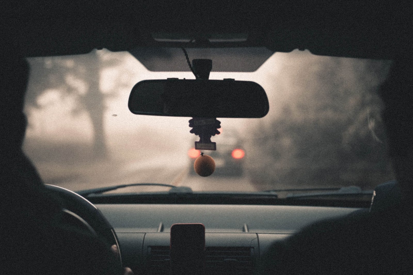 Retrovisor interior de un vehículo con carretera y paisaje al fondo