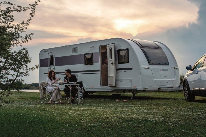 Caravana Adria instalada junto al agua durante el atardecer