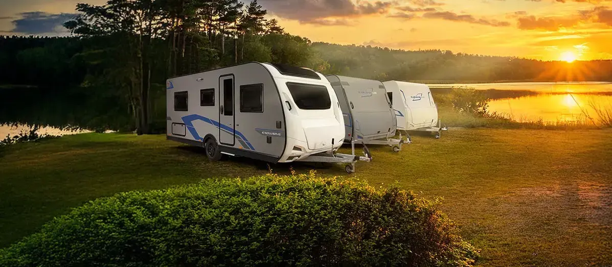 Caravana Caravelair en un camping rodeado de naturaleza al atardecer