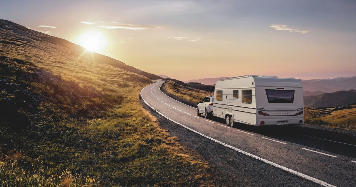 Caravana TABBERT remolcada por una carretera de montaña al atardecer