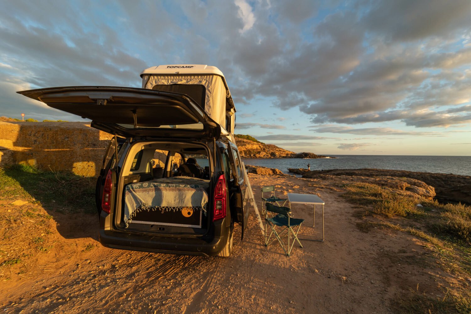 Citroën Berlingo camper con cama y techo elevable junto al mar