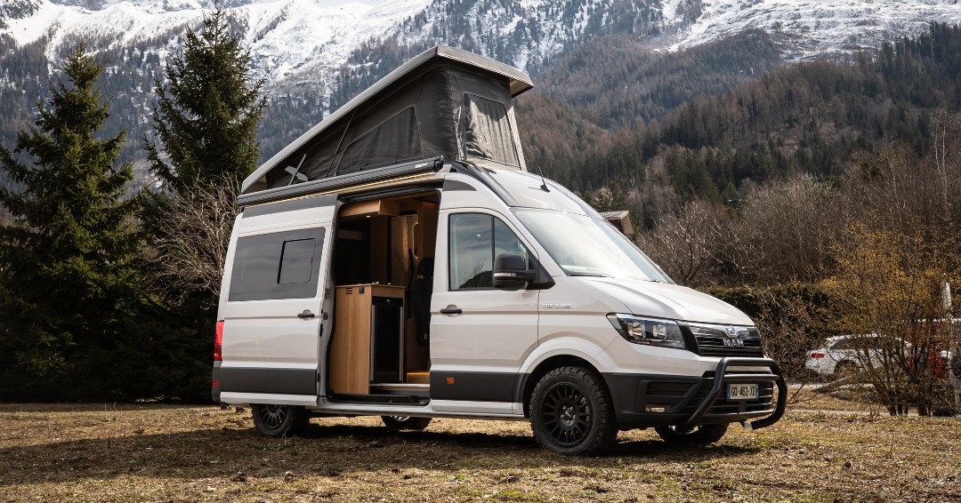 MAN TGE camper con techo elevable ante un paisaje de montaña