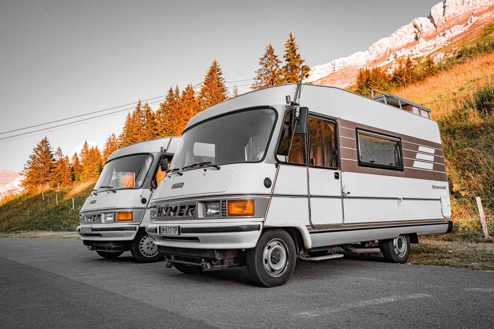 Autocaravanas y furgonetas camper en un valle de montaña al atardecer