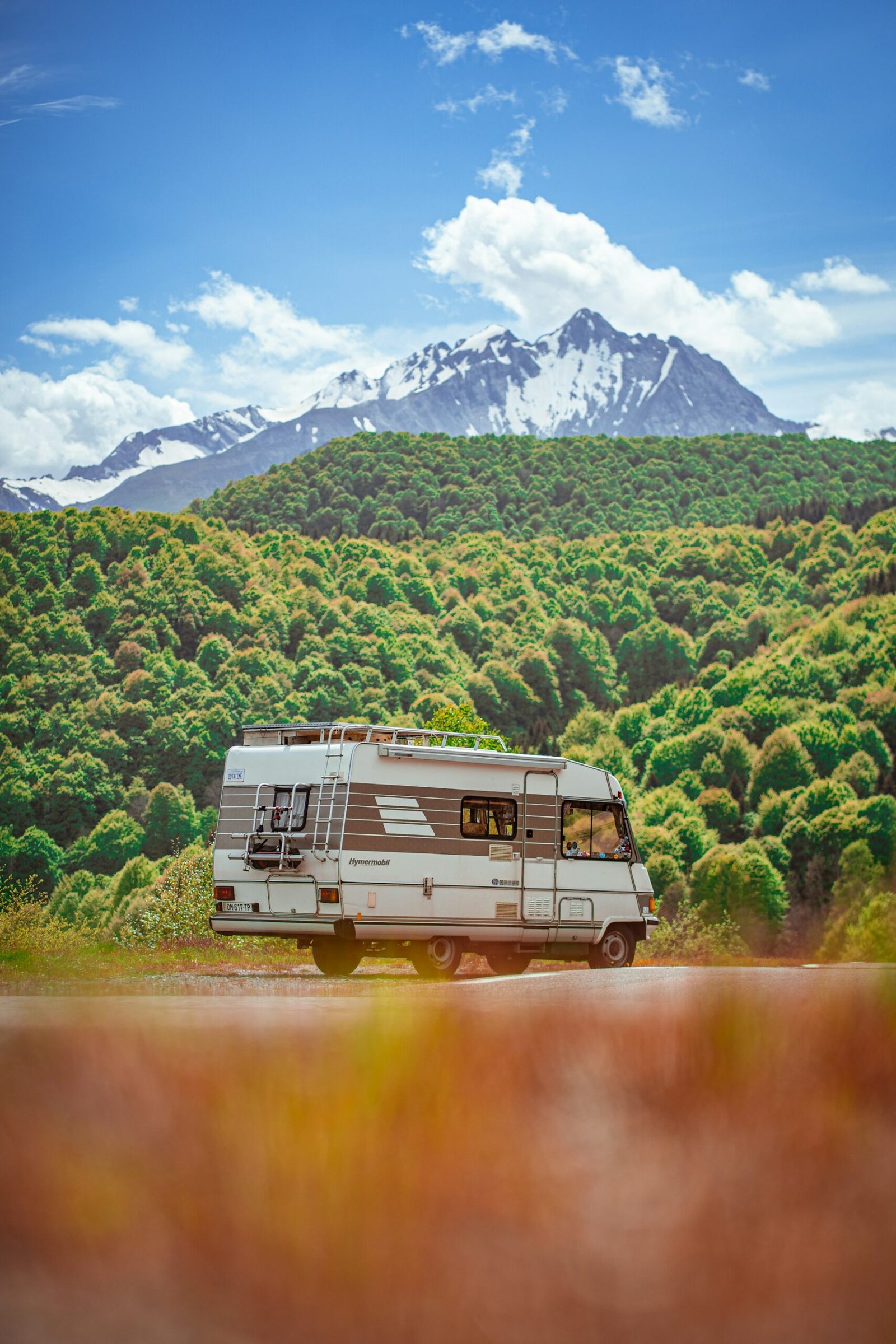 Camper recorriendo una carretera panorámica entre montañas europeas