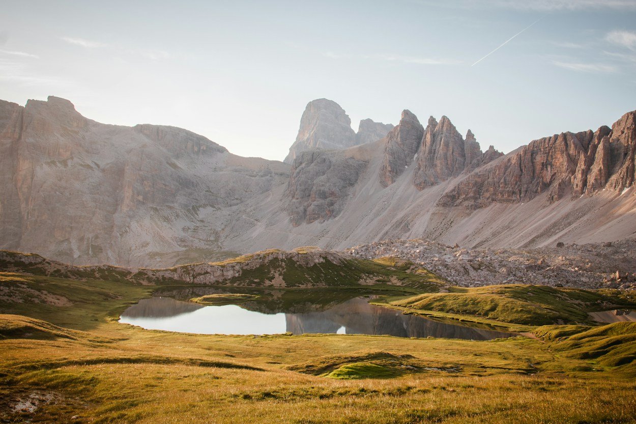 Lago en los Dolomitas con montañas escarpadas y luz de atardecer
