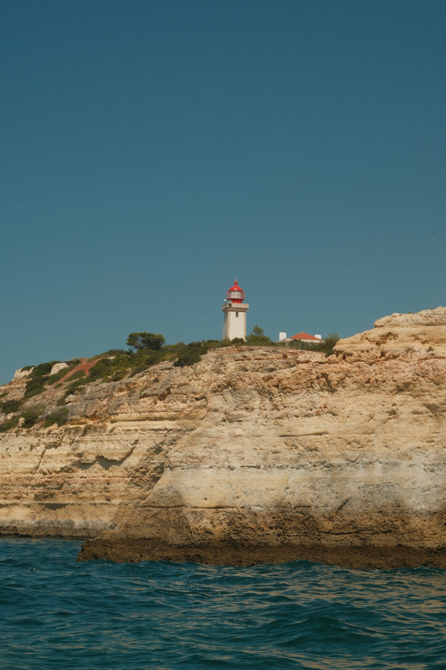 Faro del Algarve en Portugal junto a acantilados marinos