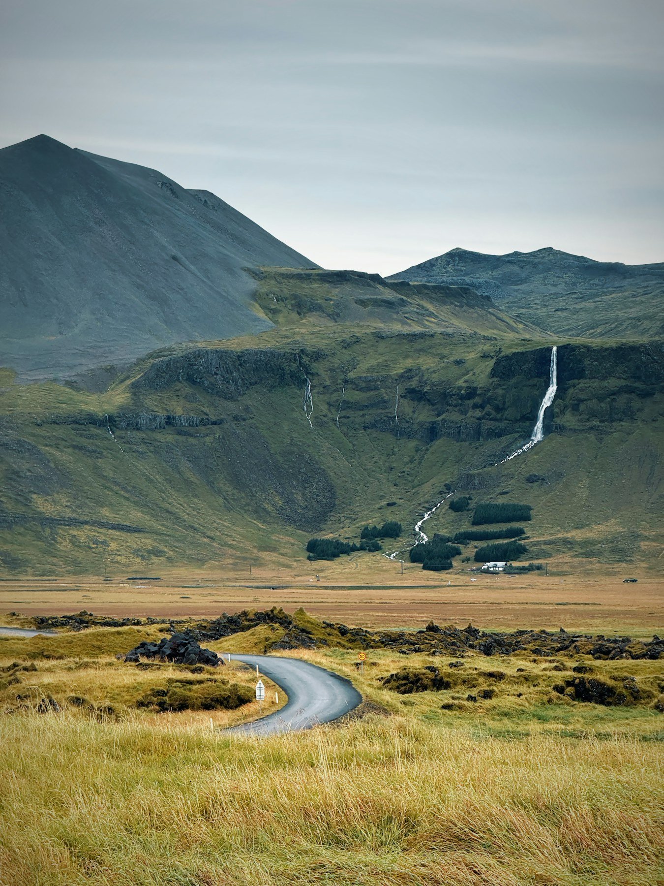 Carretera escénica entre los verdes paisajes montañosos de Islandia