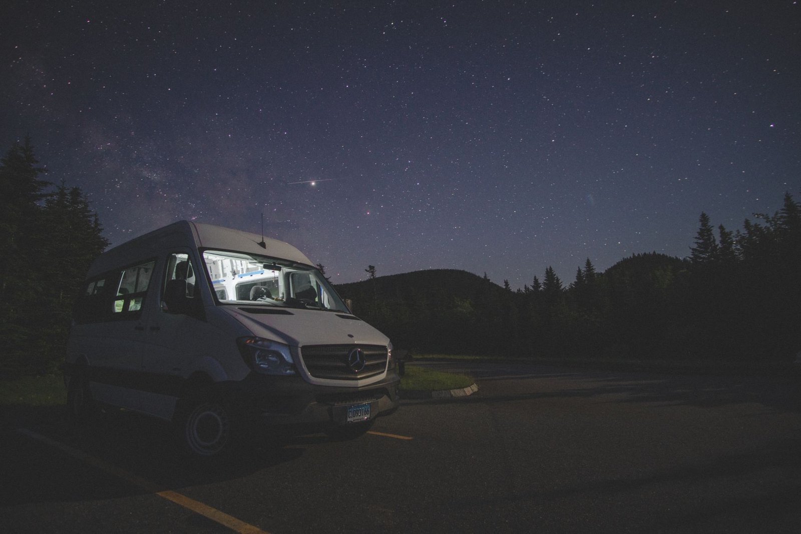Escena nocturna de una camper entre árboles bajo las estrellas, imagen editorial que no representa Chausson 720